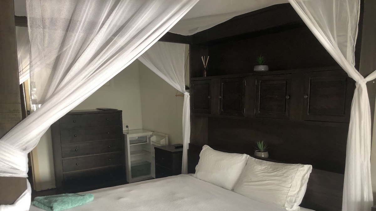 Proserpine Apartment | Clean tidy hotel room with a shared kitchen and shower area