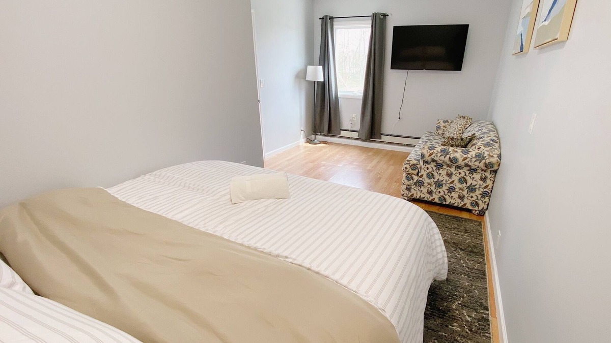 Coram Apartment | Cozy king suite with kitchen and dining area.
