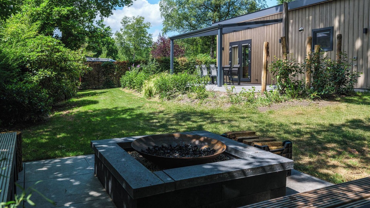 Lieren House | Enjoy a luxurious holiday home for 4 people in the wooded nature of the Veluwe, complete with modern amenities, air conditioning, a stylish pergola, and a cozy lounge area with an outdoor fireplace for ultimate comfort and ambiance, both day and nigh
