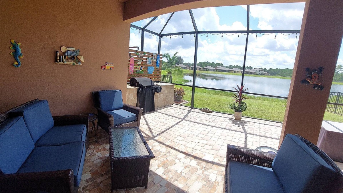 Port Malabar House | Lake view home with a screened outdoor entertainment area.