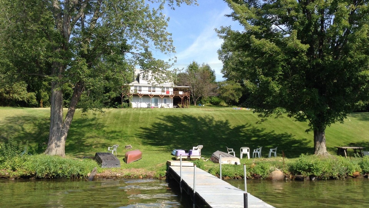 Dundee House | Large Lakefront Reunion And Retreat Home With a large lawn and wrap around porch