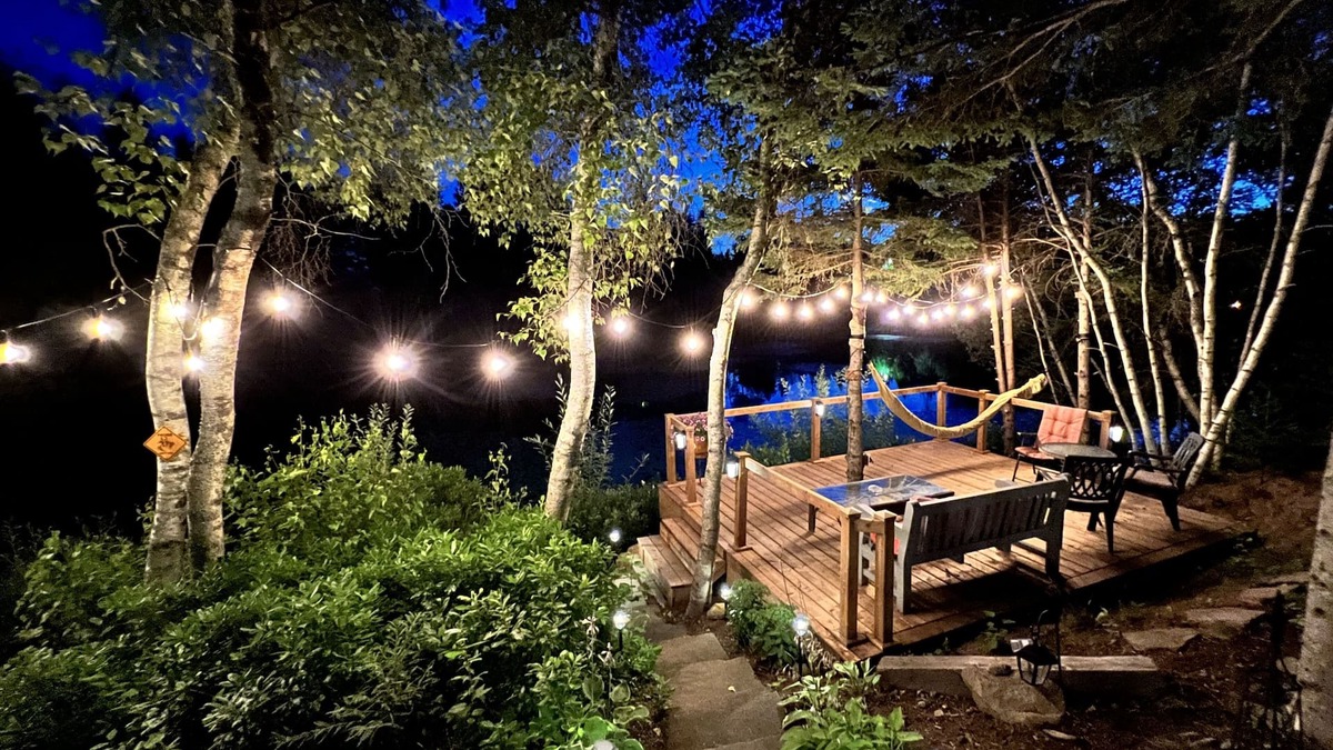 Cap-Pele Ski Chalet | Luxurious rustic wooden chalet on edge of tranquil pond in nature next to beach.