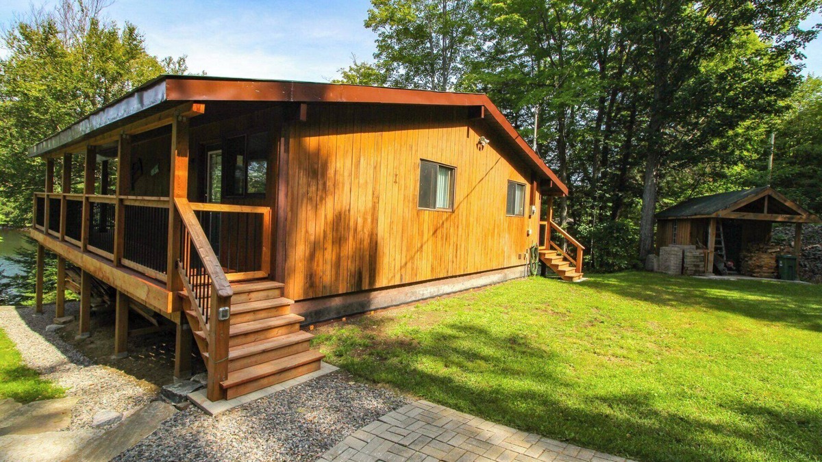 Dysart et al Cottage | Modern log cabin with wrap around deck on Little Kennisis