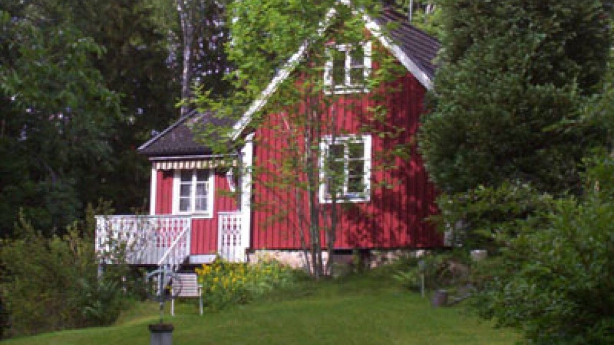 Vissefjaerda House | Red and white cottage with a boat not far from the lake