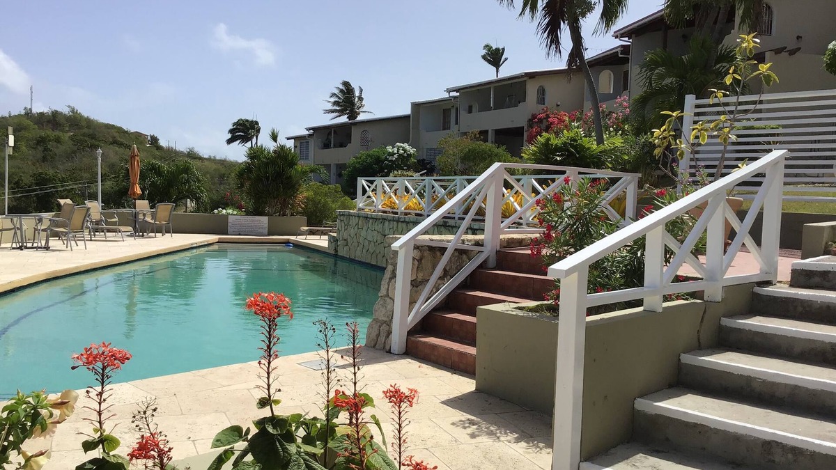 Dickenson Bay Apartment | Swimming Pool- Balcony/Veranda- Sea & Sunset Views