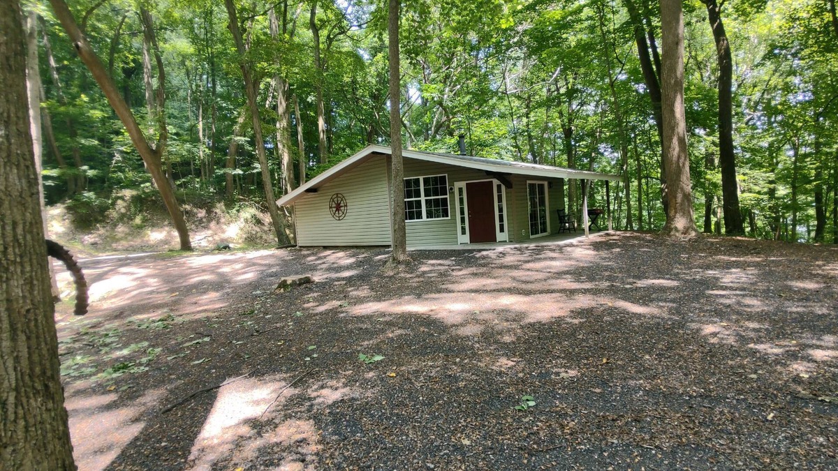 Darlington House | The Chalet is located in the woods of a gated property with a covered porch.