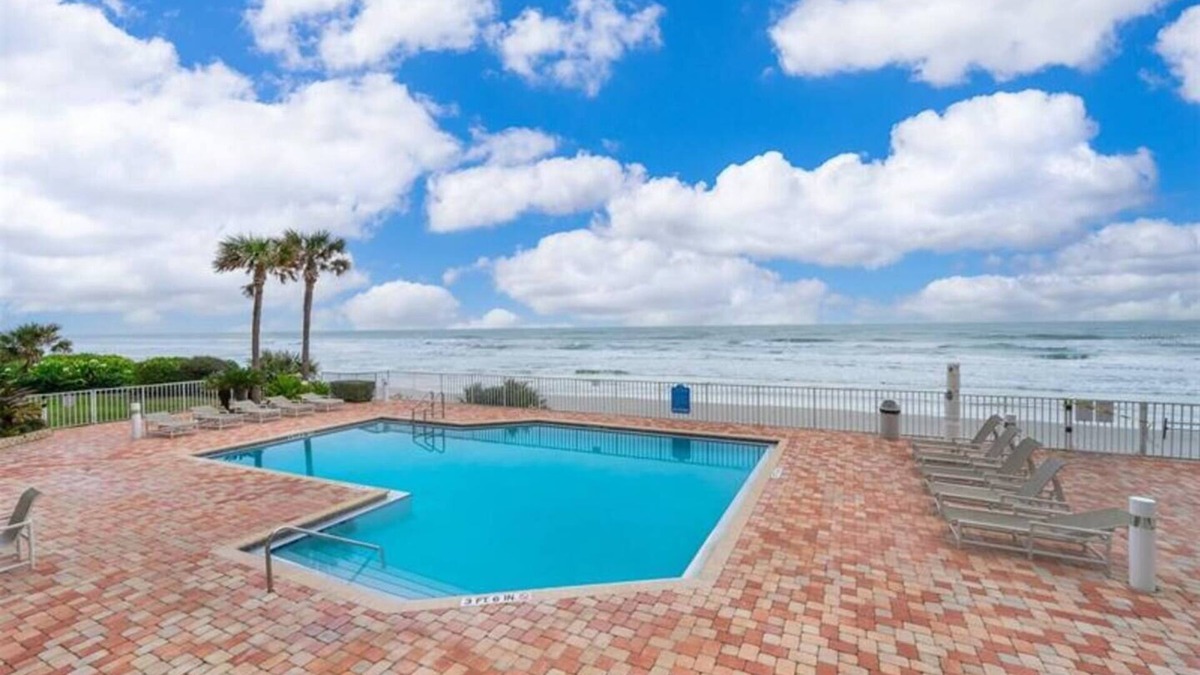 Ponce Inlet Condo | This stunning oceanfront 2BR condo in peaceful Ponce Inlet offers breathtaking beach views. Relax on the wraparound balcony with your morning coffee as pelicans glide by and dolphins surface in the waves below.