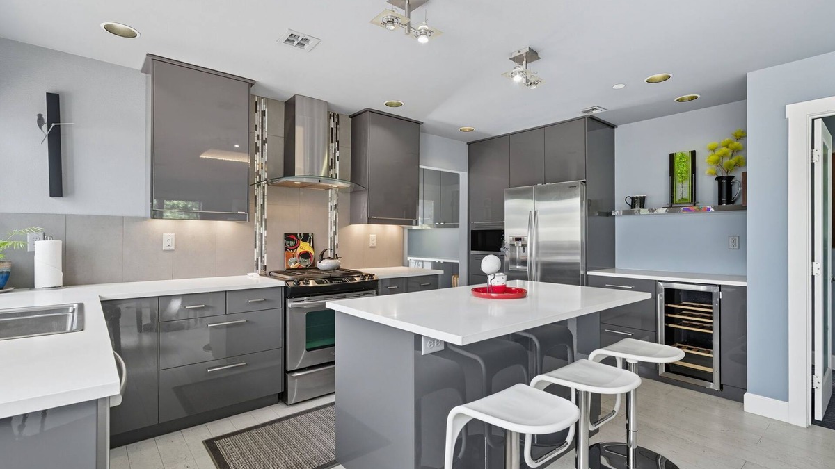 Hough Apartment | Top-level duplex featuring a sleek open concept kitchen with stainless appliances, cozy fireplace, stylish furnishings, and in-unit washer/dryer. Designed for basking in the sun under skylights in thoughtful details throughout.