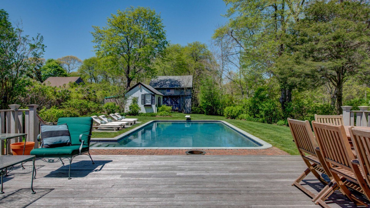 Quogue House | Traditional-style home with private pool, several sitting rooms, back deck,...