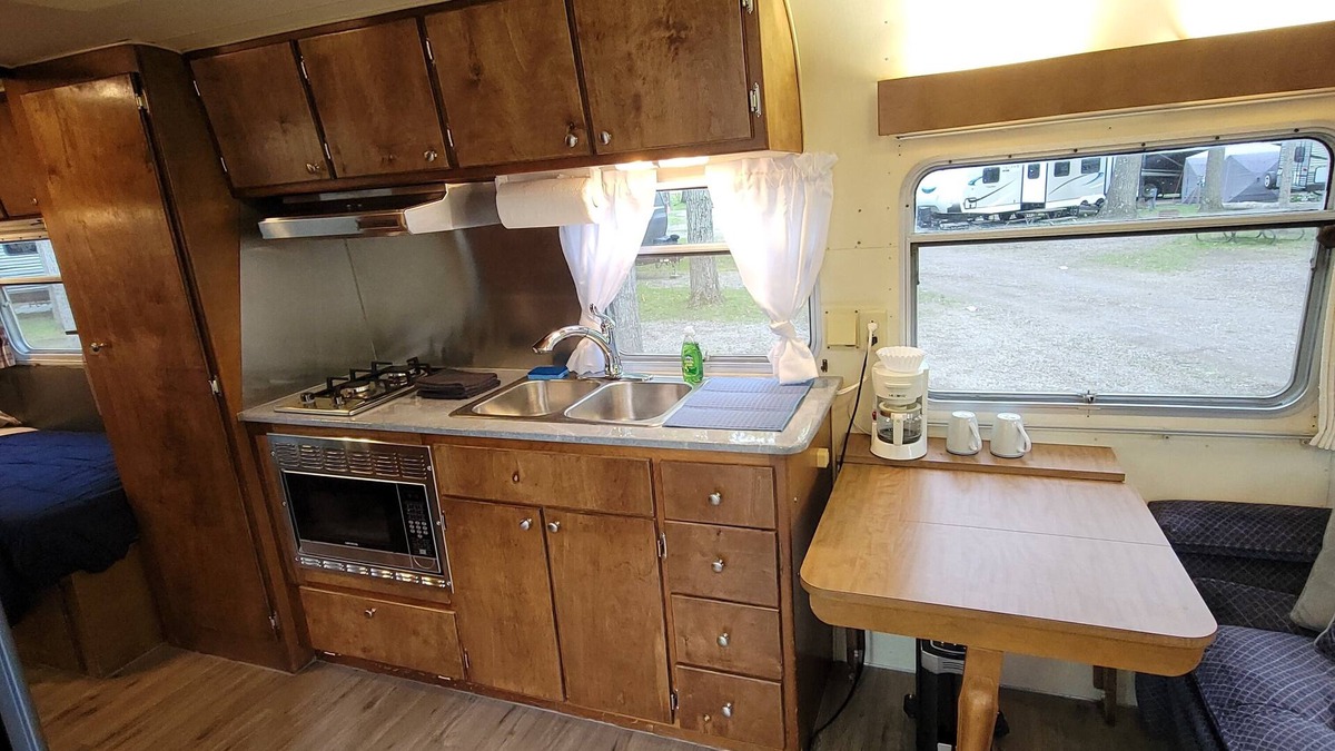 Bellaire RV Rental | Vintage Trailer Nestled into a beautifully wooded Campground