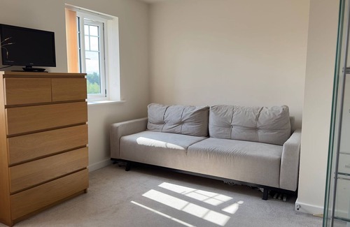 Milton Keynes House | A light spacious room,with sofa and single bed. Private bathroom with shower.