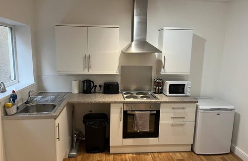 Wednesbury Apartment | Enjoy a spacious lounge with a cozy sofa bed and a private ensuite bedroom