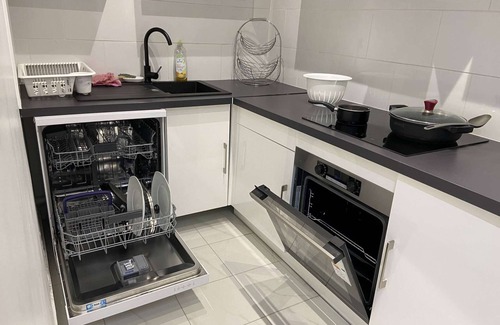 Saint-Brice-sous-Foret Apartment | L'appartement dispose d'un lit, d'un canapé-lit et d'une cuisine avec un réfrigérateur