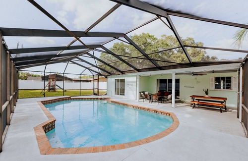 Palma Sola House | LUXE beach getaway 5mins from water. 3xKING BR, large heated pool + new playland