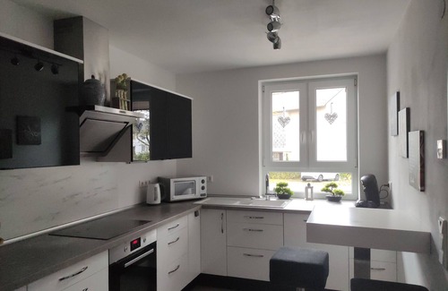 Baunatal House | Modern semi-detached house with covered terrace and fenced garden.