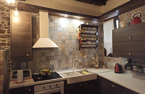 Asklipiio House | Traditional stone built single room house with traditional bed.