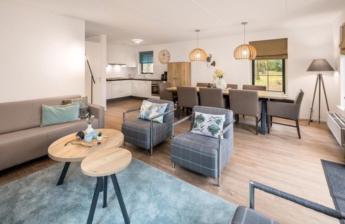 Hooghalen House | Wellness bungalow with whirlpool, sauna, sunshower, 3 bedrooms, and a covered terrace with lounge set.