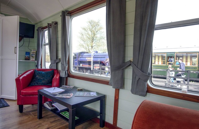 A carefully converted heritage railway coach in the countryside.