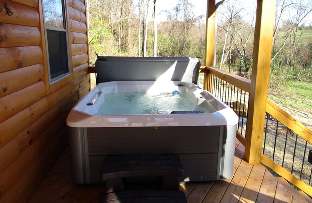 A cozy new cabin in rural setting with a hot tub on porch. Beautiful rural view.