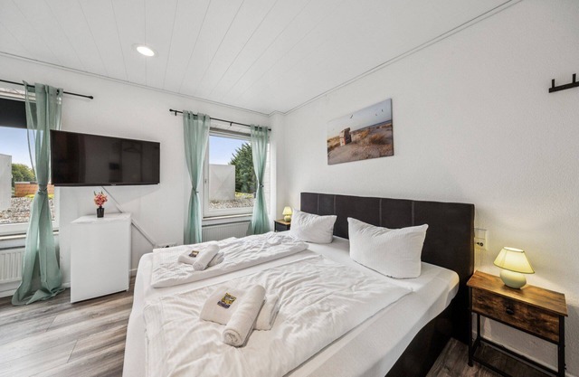 Cozy double room, flat-screen TV, and modern bathroom with shower. Ideal for couples and short stays – enjoy a relaxed atmosphere with warm wood accents and coastal charm.