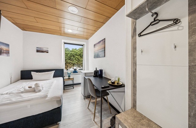 Cozy single room, flat-screen TV, and modern bathroom with shower. Ideal for singles and short stays – enjoy a relaxed atmosphere with warm wood accents and coastal charm.