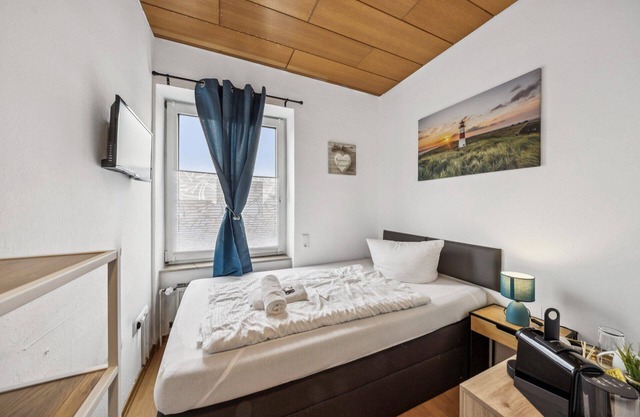 Cozy single room, flat-screen TV, and modern bathroom with shower. Ideal for singles and short stays – enjoy a relaxed atmosphere with warm wood accents and coastal charm.