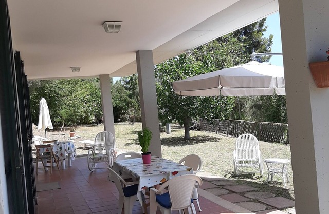 detached house, surrounded by green oaks and olive trees.
