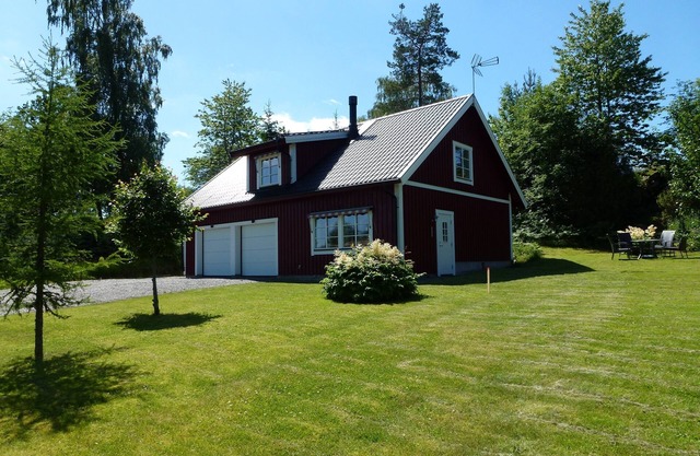 House With An Unique Gathering Of Hunting Trophies. View Of The Pond & Village