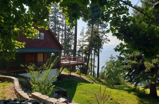 Peaceful home enveloped in a quiet, scenic landscape adjacent to a rocky beach.