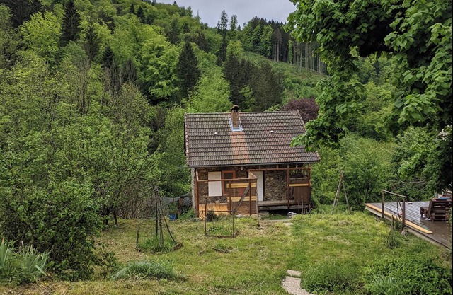 Small house surrounded by nature and mountains.