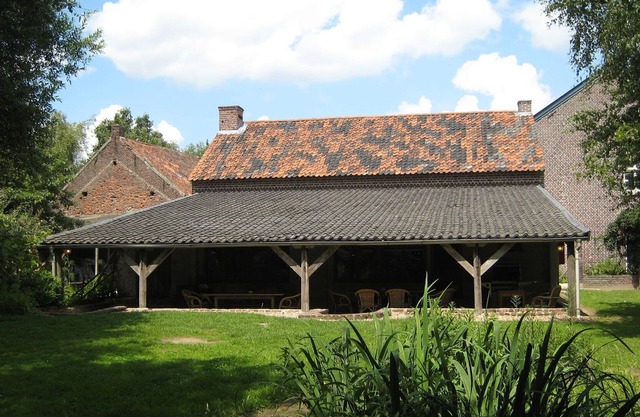 Square-shaped farmhouse in a rural area.