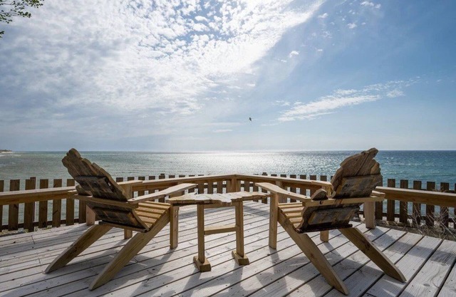 This charming vacation home sits directly on Lake Michigan and it delivers!