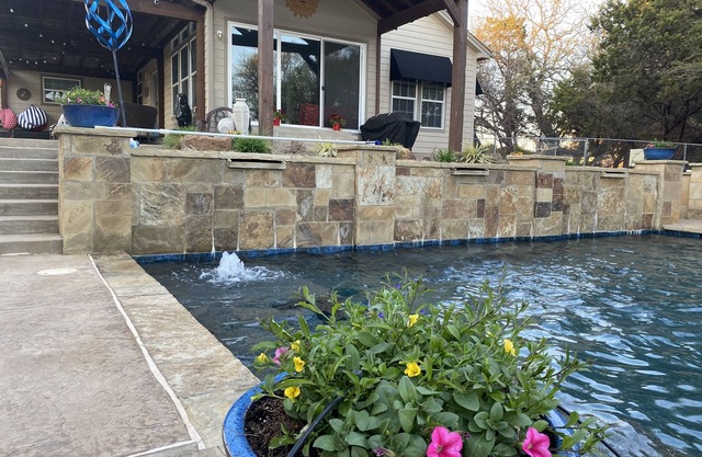 Tranquil Waterfront property with a pool, hot tub, fire-pit & large patio.
