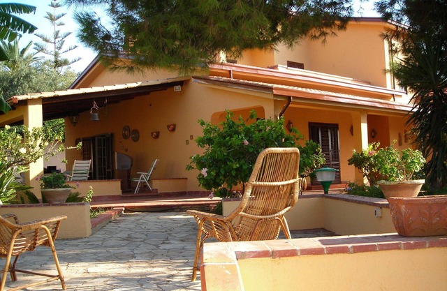 Villa 'The Plumbaco' with a large veranda and lush garden. At 5 minutes from the sea