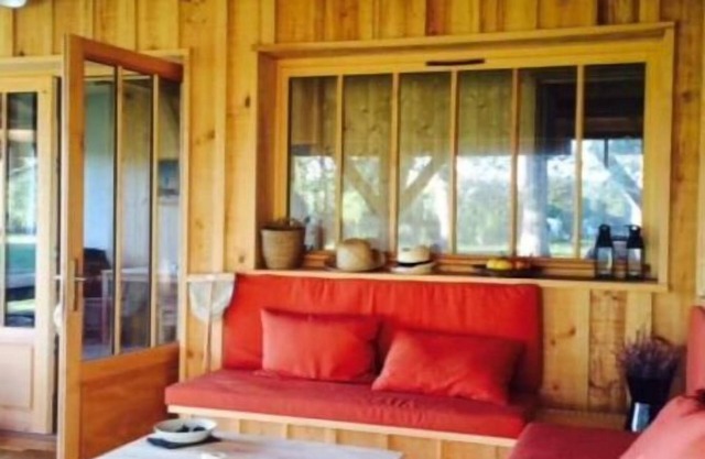 Wooden house at the Maisons Huraia between forest, lake and ocean